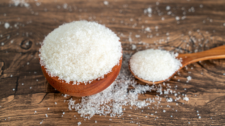 white granulated sugar in a small wooden bowl and spoon