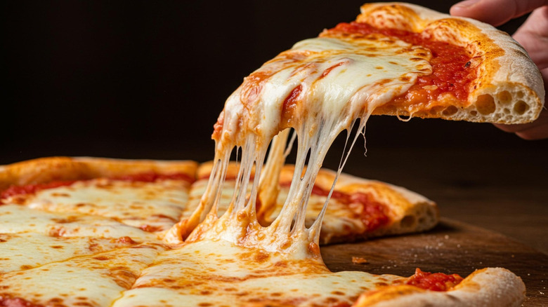 Pizza margherita with melted mozzarella cheese served on a wooden board