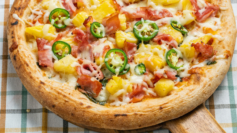 Pizza with ham, pineapple chunks, jalapenos, and melted cheese