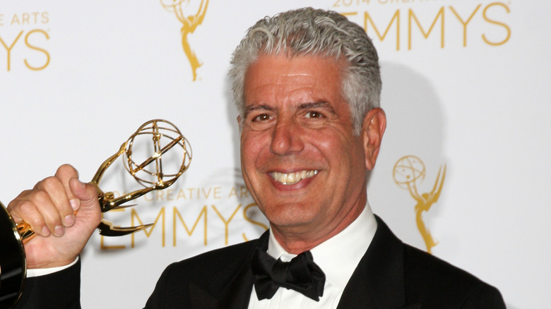 Anthony Bourdain holding an Emmy award