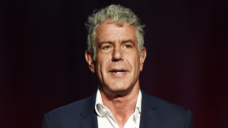 Anthony Bourdain speaking in a suit