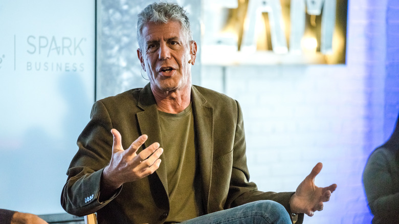 Anthony Bourdain sitting down and speaking at a business event.