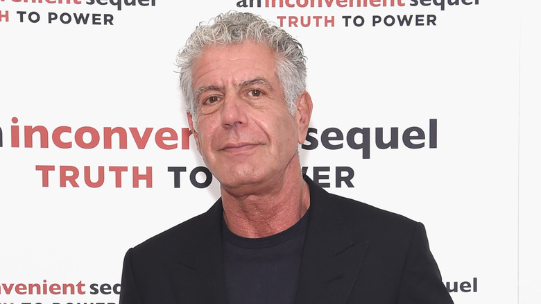 Anthony Bourdain wearing a black blazer and t-shirt at an event