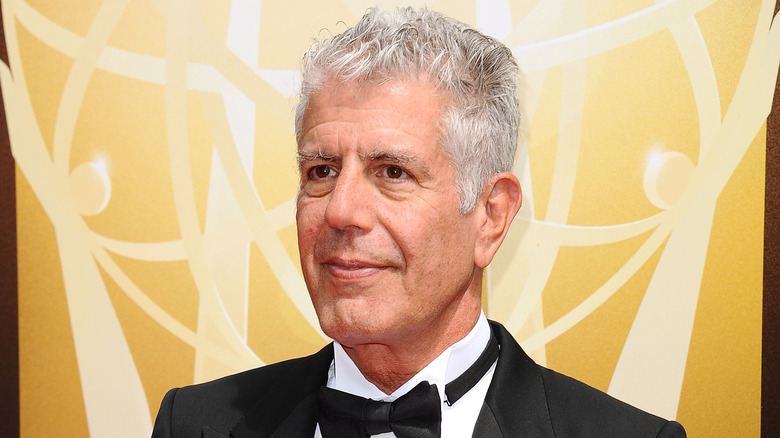 Anthony Bourdain wearing a tuxedo and smiling slightly