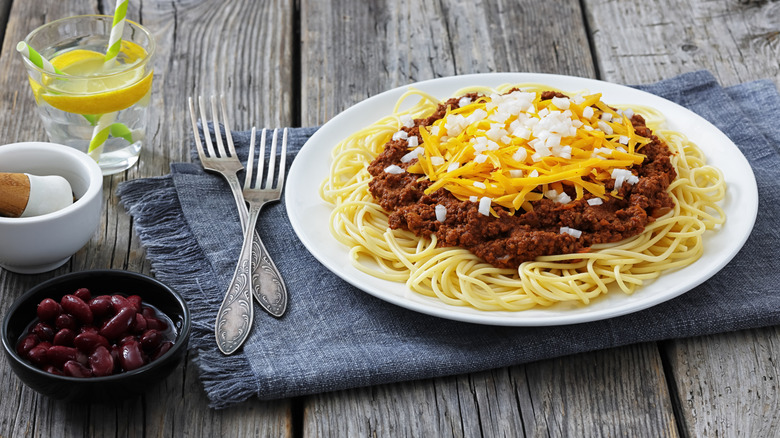 Cincinnati Chili with a side of beans and a glass of water with lemon