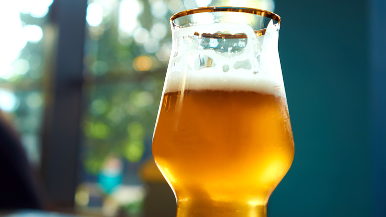 An amber beer in a gold-rimmed glass