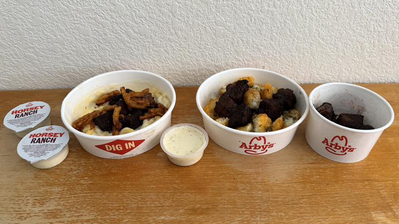 Arby's Steak 'n Mac Bowl, Steak 'n Potato Bowl, and Steak Nuggets with Horsey Ranch Sauce on a wooden table