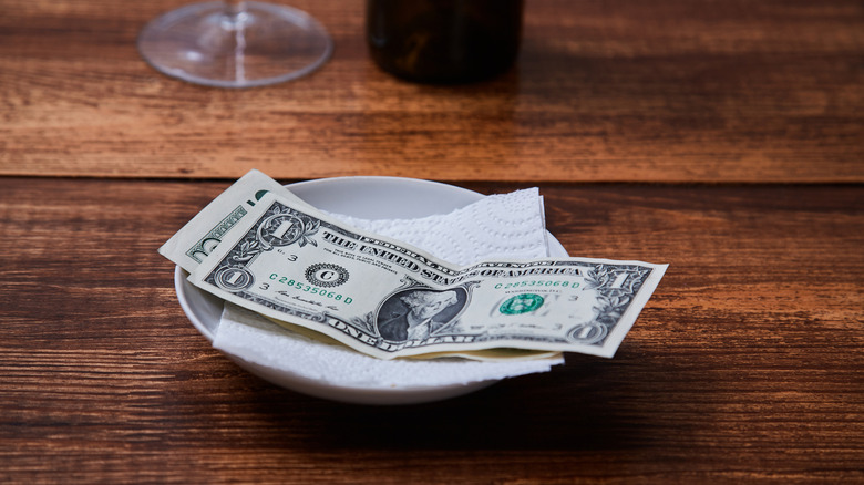 Plate with $6 on it on top of table