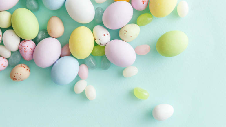 Pastel colored egg candies on mint green
