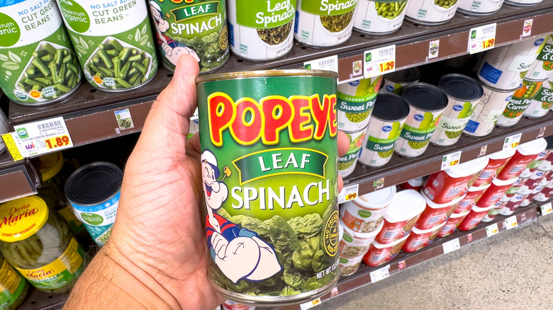 hand holding a can of popeye spinach