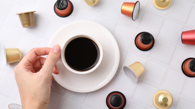 Cup of espresso surrounded by coffee pods