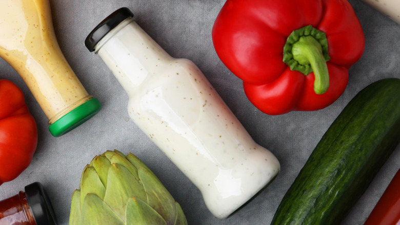 Glass bottle of ranch dressing and assorted produce