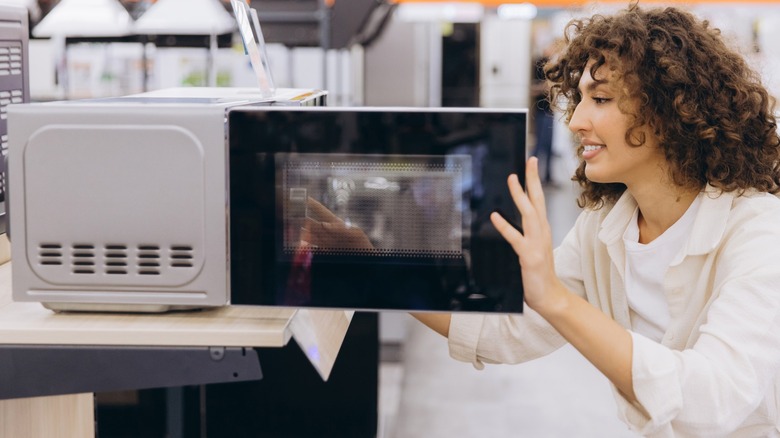 Person shopping for a microwave at the store.