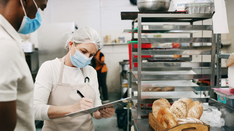 A health inspector inspecting a restaurant kitchen.