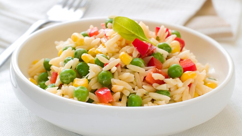 Bowl of orzo pasta with veggies mixed in