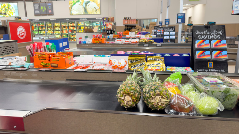 Aldi checkout belt with fruits, vegetables, and candy