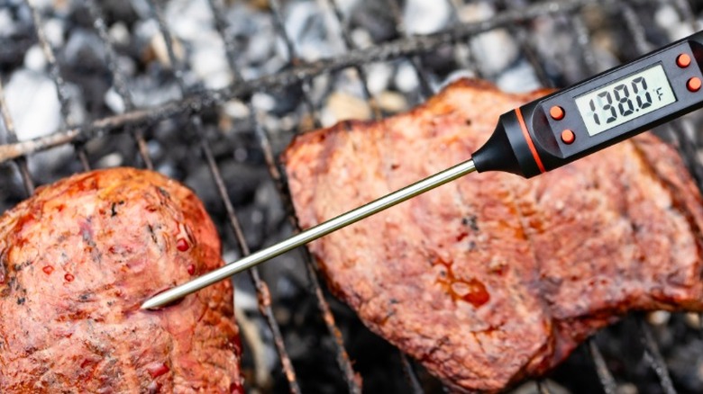 A meat thermometer inserted horizontally into a piece of steak.
