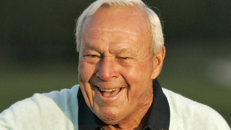 Arnold Palmer smiling on a golf course