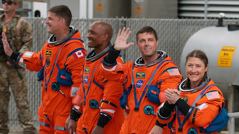 The crew of the Artemis 2 space mission waving at the crowd before launch.