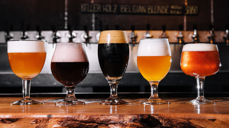 Several craft beers of different types on a rustic wooden bar