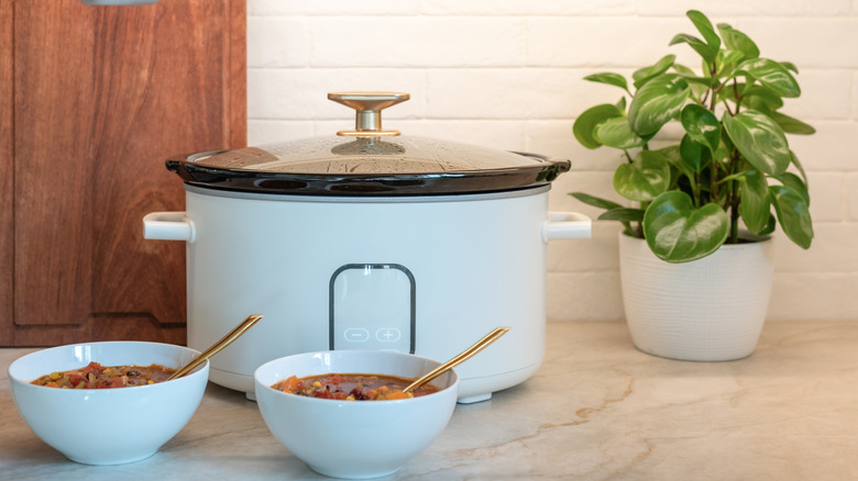 Slow cooker with bowls of chili