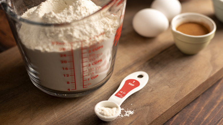 Measuring spoon of flour and measuring jug of flour