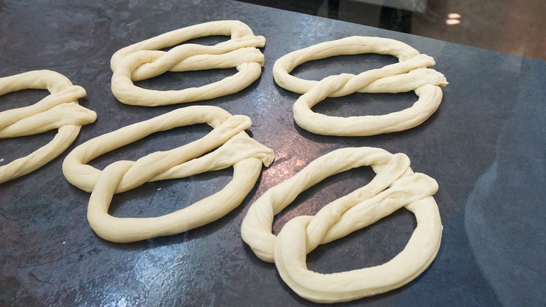 Raw pretzel dough in knot shapes