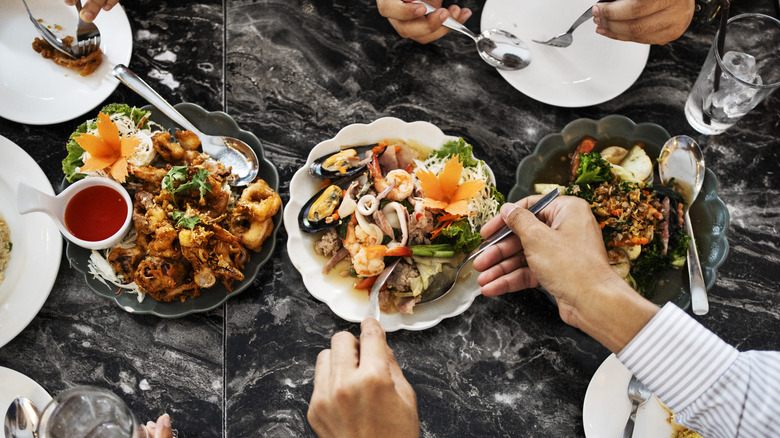 Top view of people sharing Thai food at a restaurant