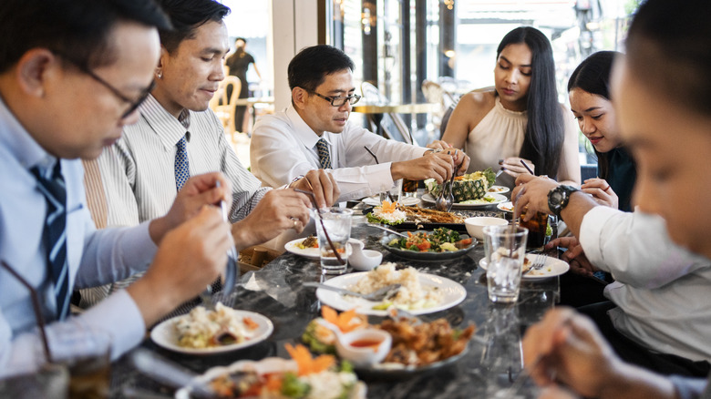 Group of business professionals enjoying dinner at a Thai restaurant after work