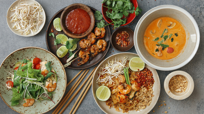 Authentic classic Pad Thai with shrimps. Thai shrimp satay with sweet chili sauce. Tom Yum soup with coconut milk