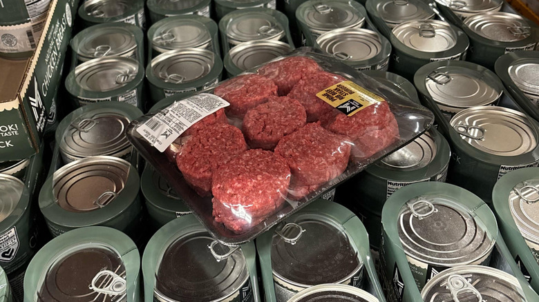 A package of Kirkland beef patties left on a case of canned chicken breast