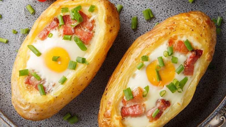 Eggs and bacon on top of two baked potatoes