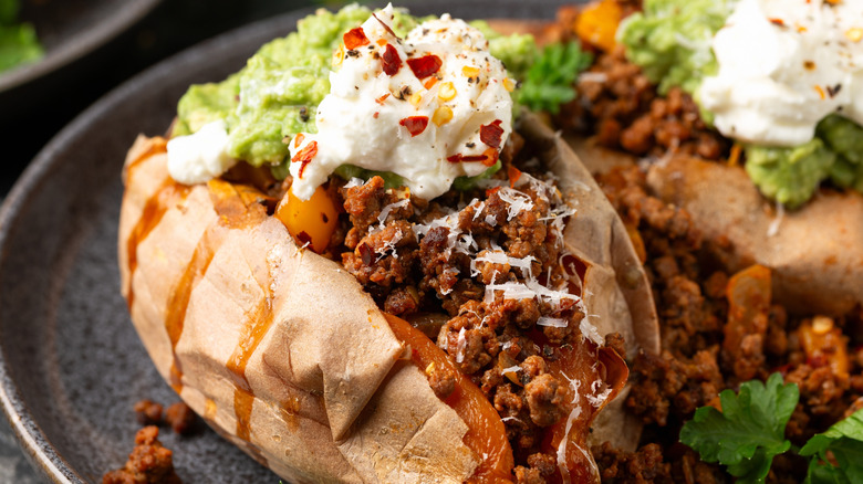 A sweet potato topped with taco fixings