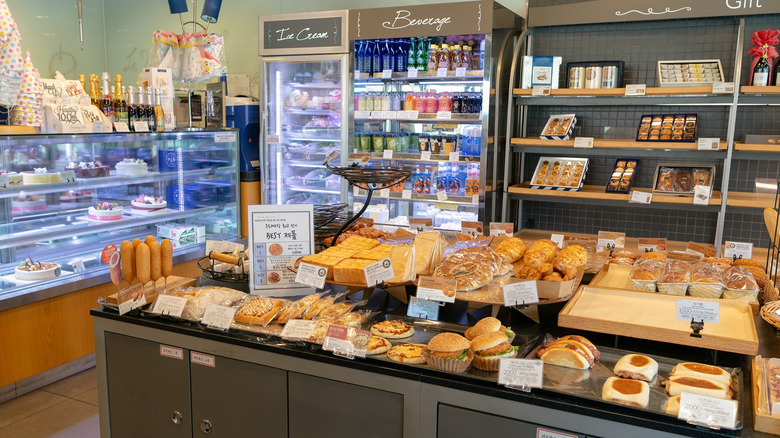 Interior of Paris Baguette bakery with fresh pastries and bread on display and more desserts behind glass counter