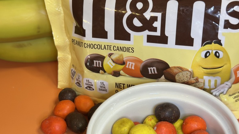 Bag of M&Ms Banana Nut Bread packaging with candies in white ramekin