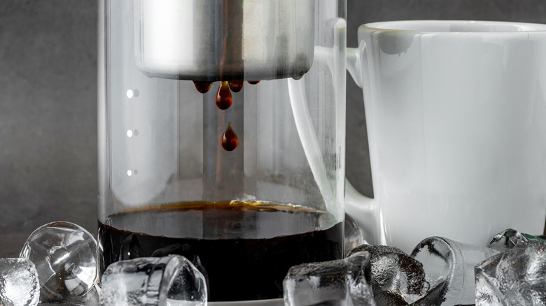 Cold brew coffee dripping into a container as it brews