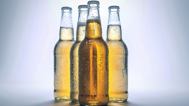 Four frosty clear beer bottles