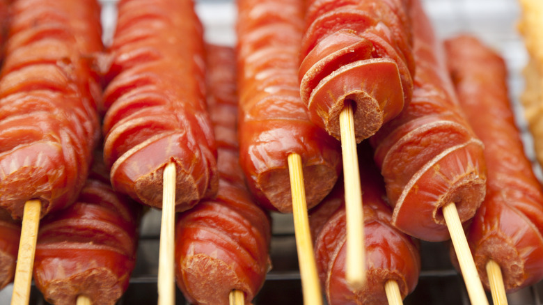 Scored spiral hot dogs on skewers