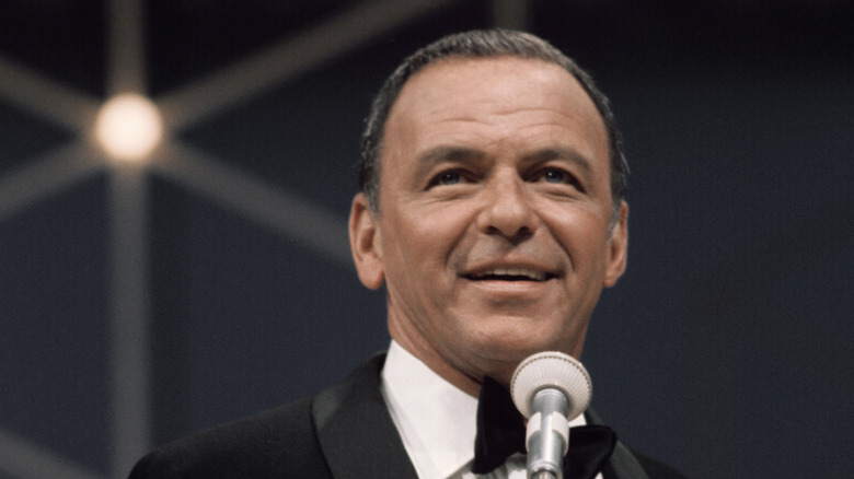 Frank Sinatra standing behind microphone