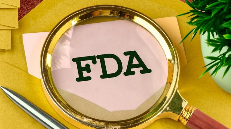 The letters "FDA" under a magnifying glass.