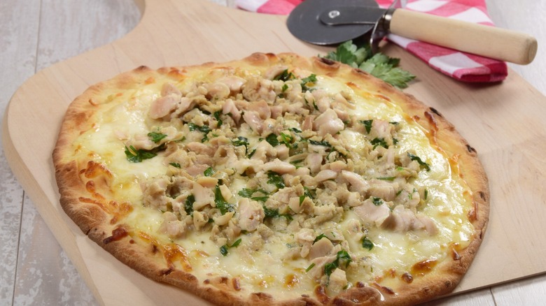 New Haven-style thin crust white clam pizza on a pizza paddle