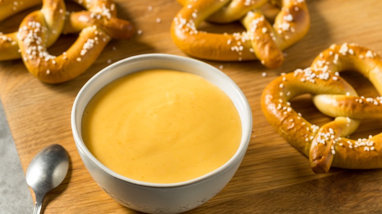 Beer cheese dip with pretzels ion a wooden background