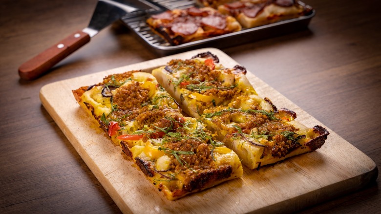 Slices of Detroit-Style Pizza on a wooden cutting board