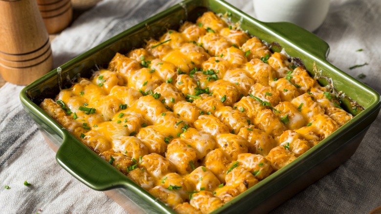 Tater tot hotdish in a green casserole pan