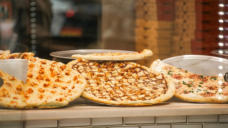Assorted New York-style pizzas on display