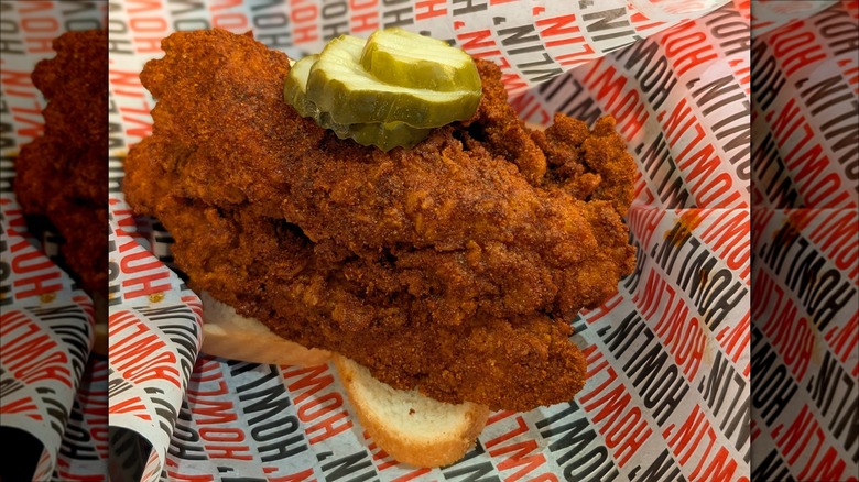 Nashville hot chicken served on bread and garnished with pickle slices