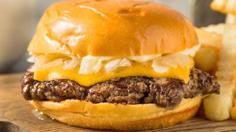 Wisconsin butter burger  with cheese and fries on a wooden surface