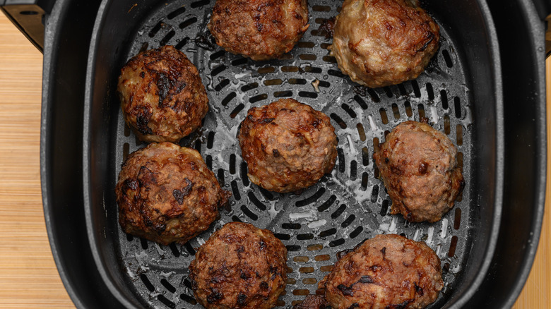 Baked ground meatballs in an air fryer basket