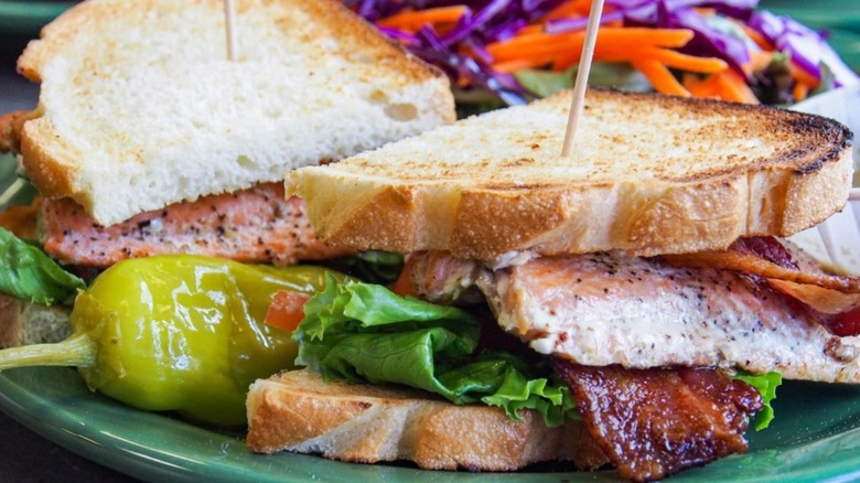Snow City Cafe Salmon BLT on a green plate with a pepper