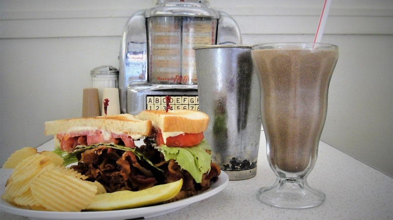 Crown Candy Kitchen Heart Stopping BLT on table with a chocolate milkshake and old school mini jukebox in background